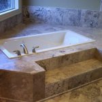 beige granite white bathtub surrounded with beige granite