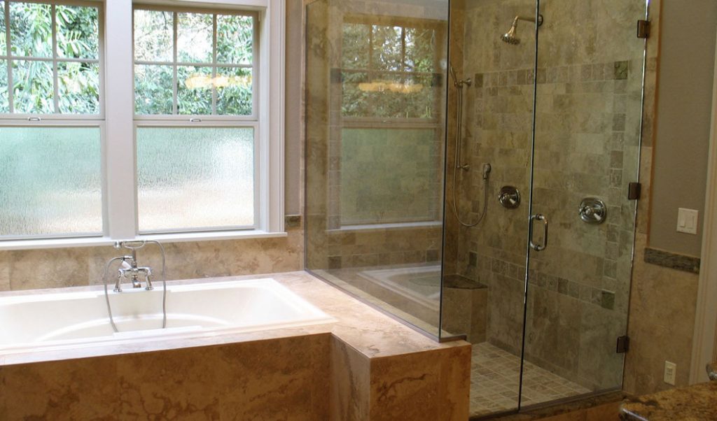 white bathtub surrounded with brown granite
