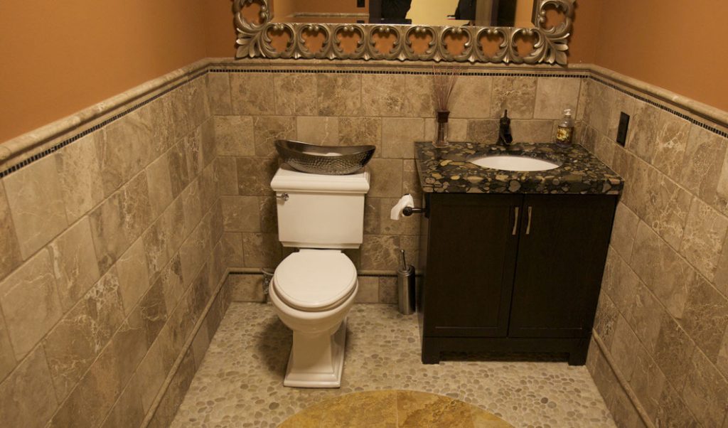 bathroom with beige floor and wall tiles and a black counter