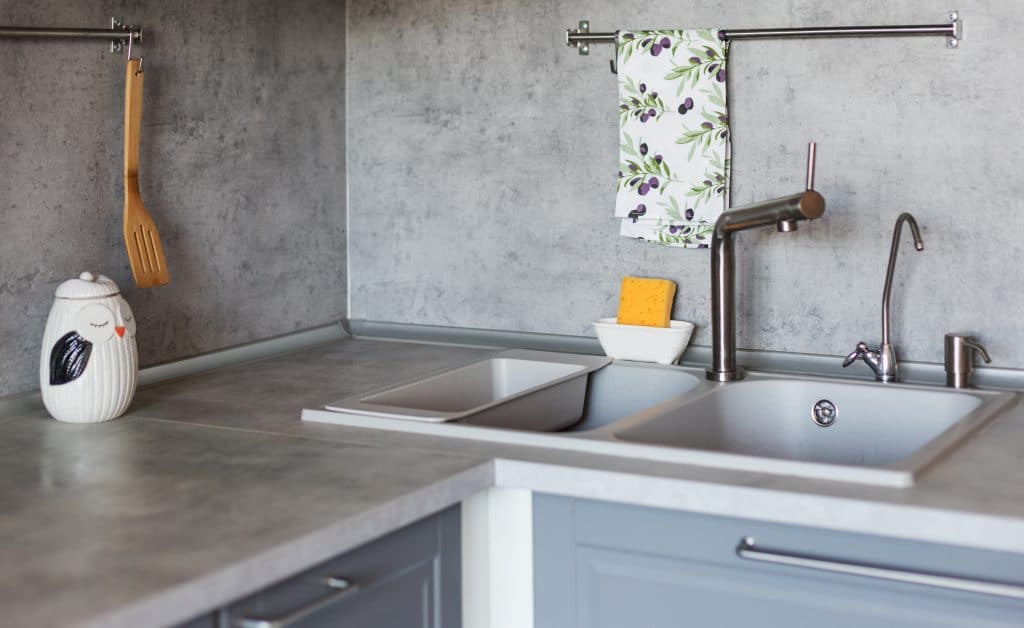 Kitchen equipment on gray kitchen. Stone grey sink, kitchen towel and work surface